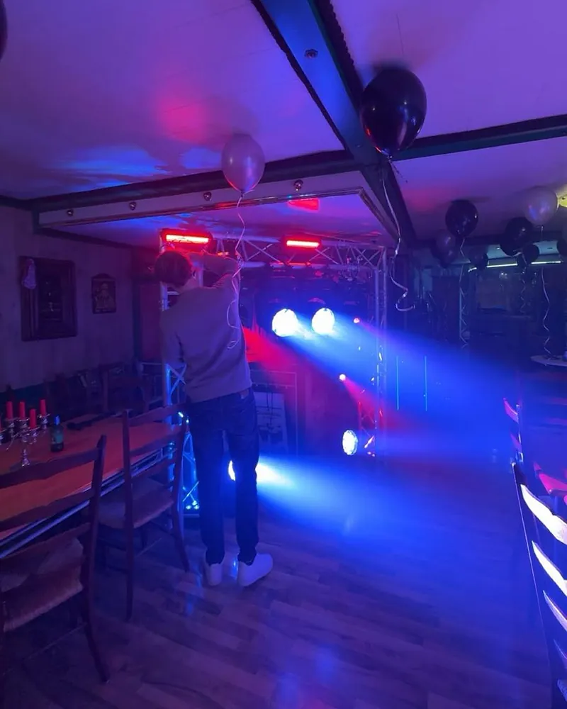 Partyraum mit Ballons, roten Lightbars und blauen Lichtstrahlen beim Aufbau