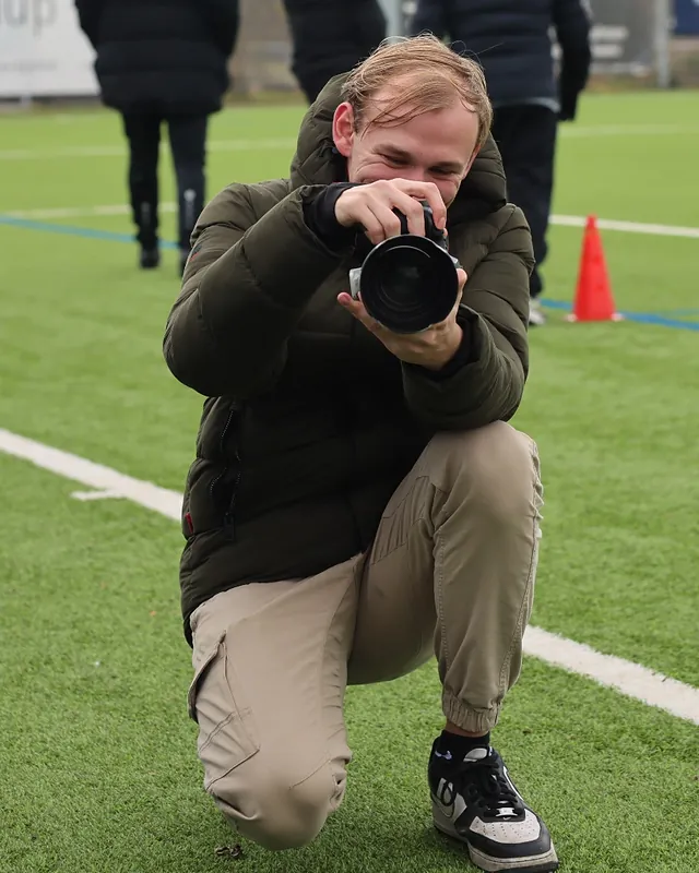 Cédric Jaggi fotografiert kniend am Spielfeldrand
