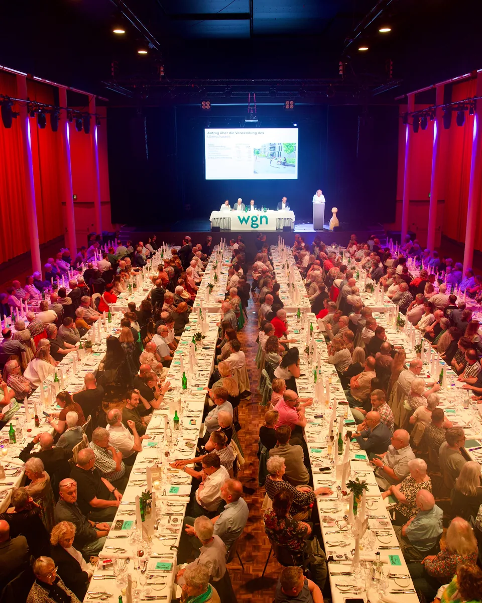 Voller Saal im Volkshaus mit langen Tischreihen, vorne die Bühne mit Leinwand und Vorstandstisch